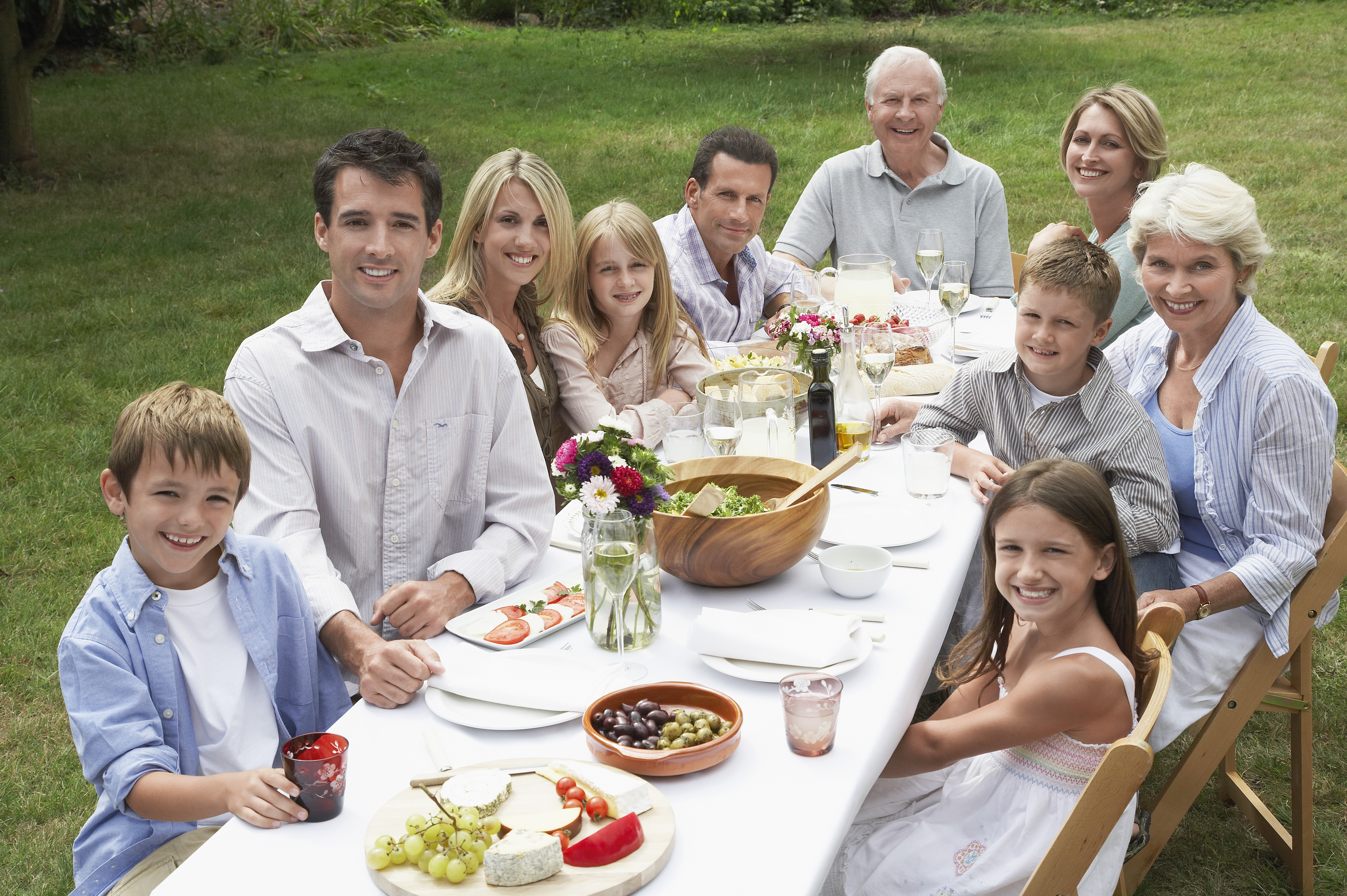 Three generation family dining in garden